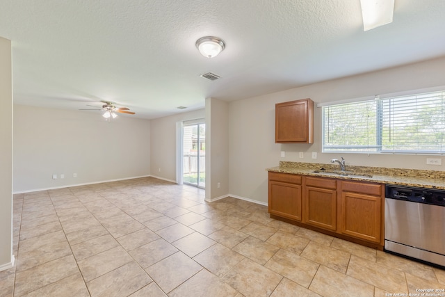 kitchen featuring a healthy amount of sunlight, stainless steel dishwasher, sink, and ceiling fan