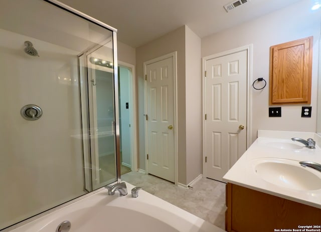 bathroom with vanity and shower with separate bathtub