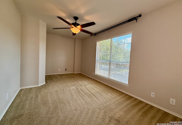 carpeted spare room featuring ceiling fan