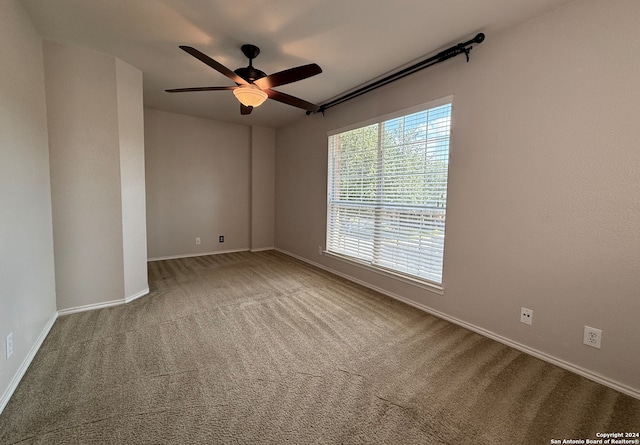 carpeted spare room featuring ceiling fan