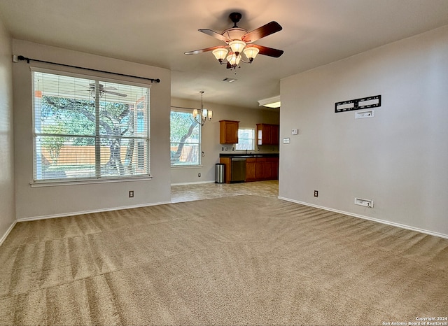 unfurnished living room with light carpet and ceiling fan with notable chandelier