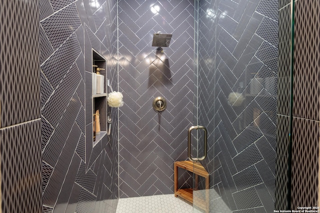 bathroom featuring a shower with door and tile walls