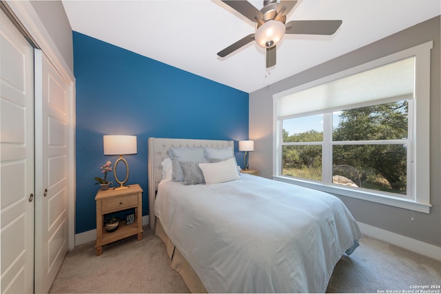 carpeted bedroom featuring ceiling fan and a closet