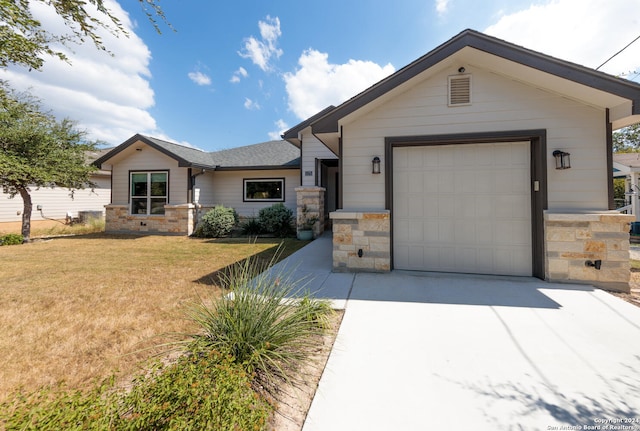 view of front of home with a front yard and a garage