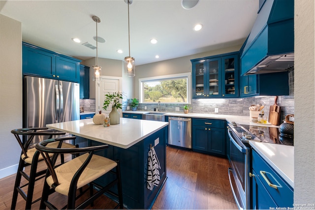 kitchen with a center island, exhaust hood, stainless steel appliances, and blue cabinetry