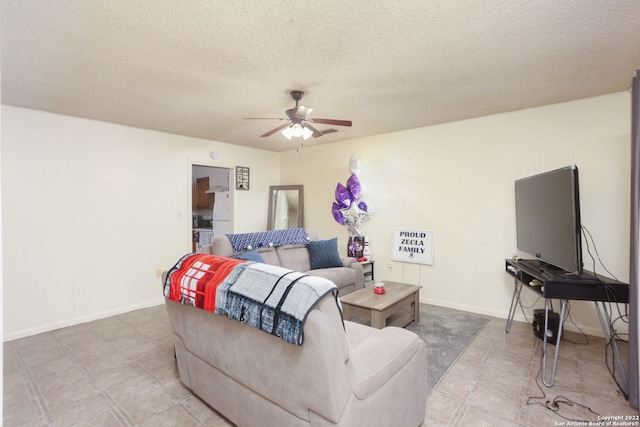 living room with a textured ceiling and ceiling fan