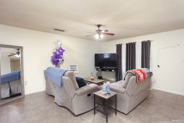 living room with a textured ceiling and ceiling fan