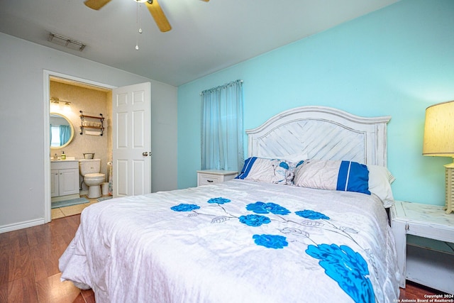 bedroom featuring ceiling fan, ensuite bath, and dark hardwood / wood-style floors