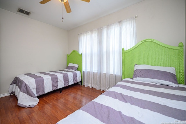 bedroom with ceiling fan and dark hardwood / wood-style flooring