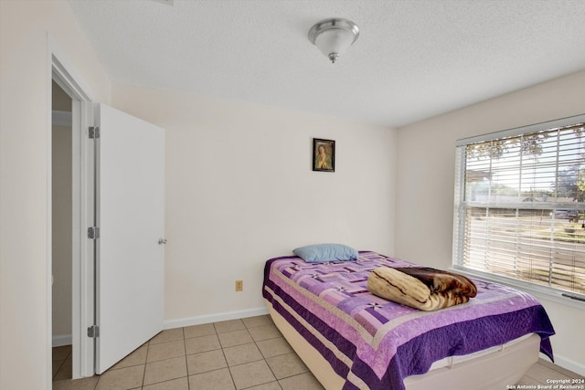 tiled bedroom featuring a textured ceiling