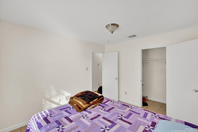 unfurnished bedroom featuring a closet, light tile patterned floors, and a textured ceiling