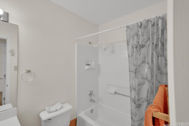 full bathroom featuring shower / bath combo, toilet, a textured ceiling, and vanity