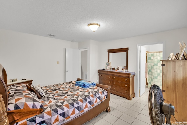 bedroom featuring light tile patterned floors and a textured ceiling