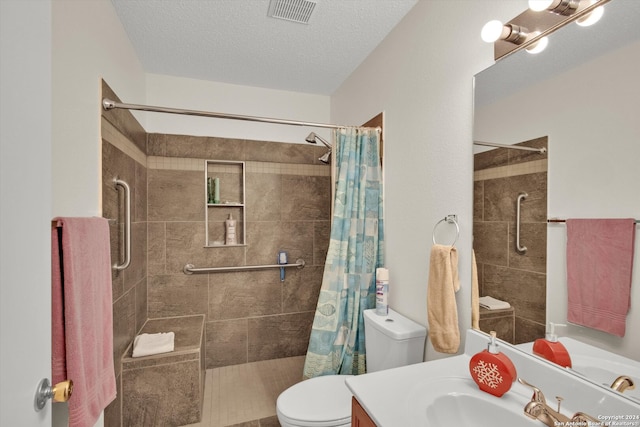 bathroom with vanity, curtained shower, toilet, and a textured ceiling