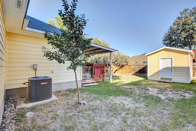 view of yard featuring a storage shed and central air condition unit