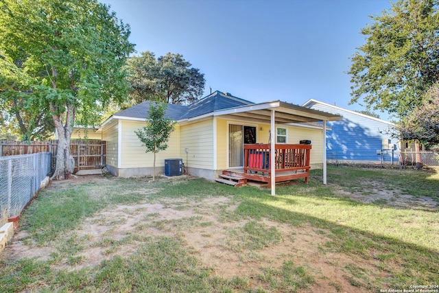 back of property featuring a lawn, a wooden deck, and cooling unit