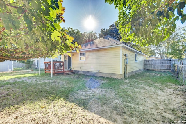 exterior space featuring a wooden deck and a lawn