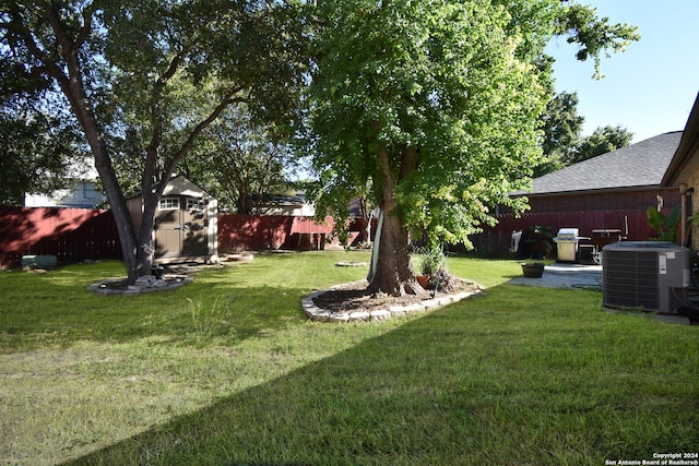 view of yard featuring a storage shed, a patio area, and central AC