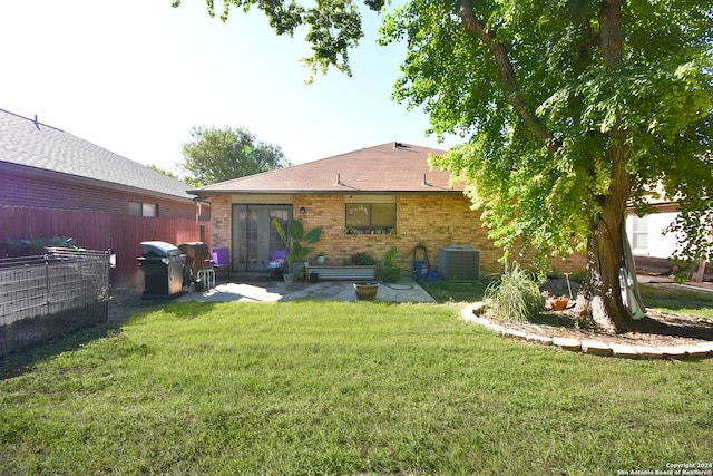 back of property featuring a yard, french doors, central AC unit, and a patio area