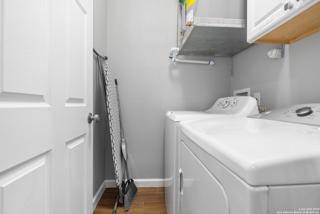 washroom with cabinets, hardwood / wood-style flooring, and independent washer and dryer