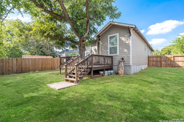 back of house featuring a lawn and a wooden deck