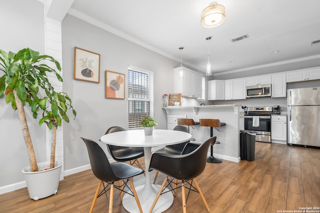 dining area featuring hardwood / wood-style floors and crown molding