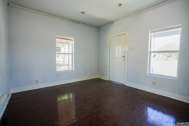 spare room featuring ornamental molding and dark hardwood / wood-style floors