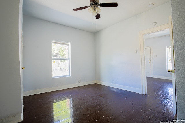 empty room with ceiling fan and dark hardwood / wood-style flooring