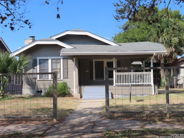 bungalow-style home with a front lawn and covered porch