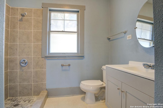 bathroom featuring vanity, tile patterned floors, toilet, and tiled shower