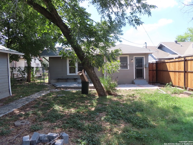 back of property featuring a lawn and a deck