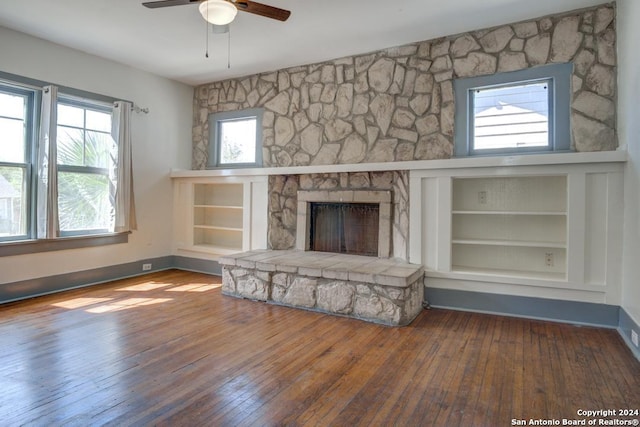 unfurnished living room featuring a fireplace, hardwood / wood-style floors, ceiling fan, and plenty of natural light