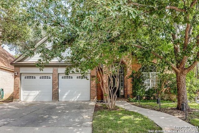 view of property hidden behind natural elements with a garage