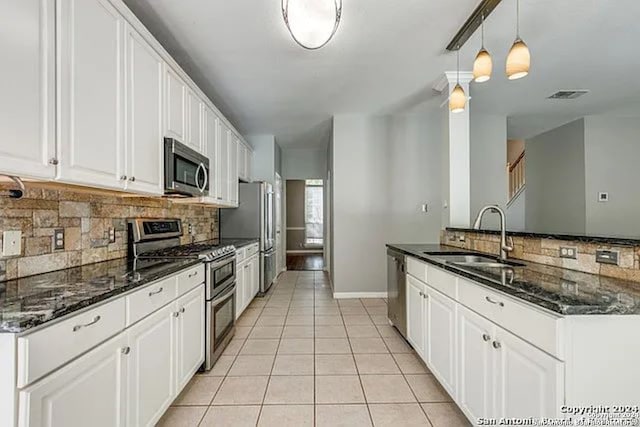 kitchen featuring stainless steel appliances, white cabinetry, and sink