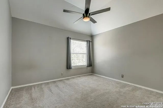 empty room featuring ceiling fan, light colored carpet, and lofted ceiling