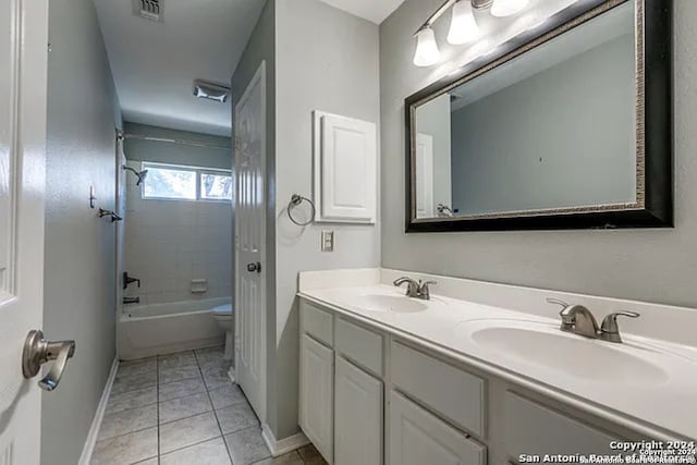 full bathroom with vanity, tiled shower / bath combo, toilet, and tile patterned flooring