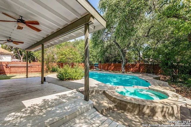 view of pool with ceiling fan, a deck, and an in ground hot tub