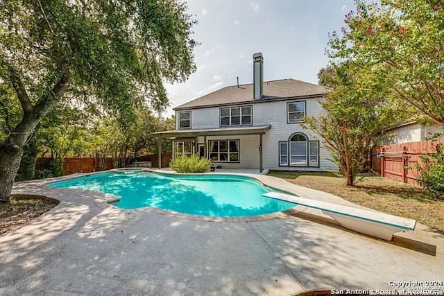 view of pool with a diving board and a patio area