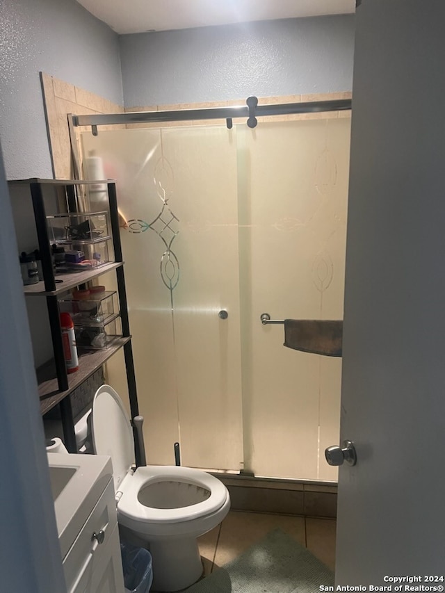 bathroom with toilet, vanity, and tile patterned floors