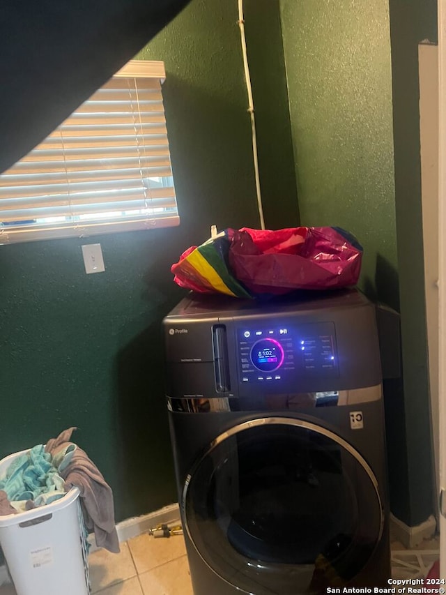 laundry area featuring washer / dryer and light tile patterned floors