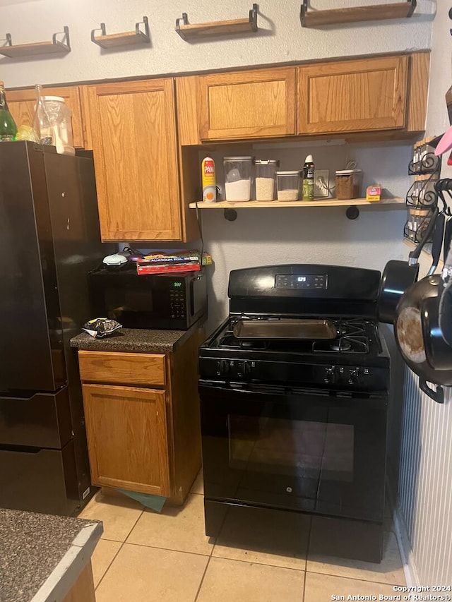 kitchen with black appliances and light tile patterned flooring