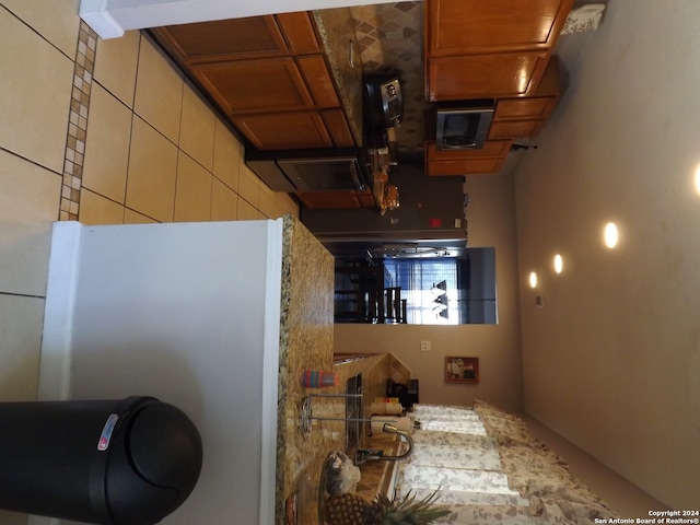 kitchen featuring white refrigerator and a towering ceiling