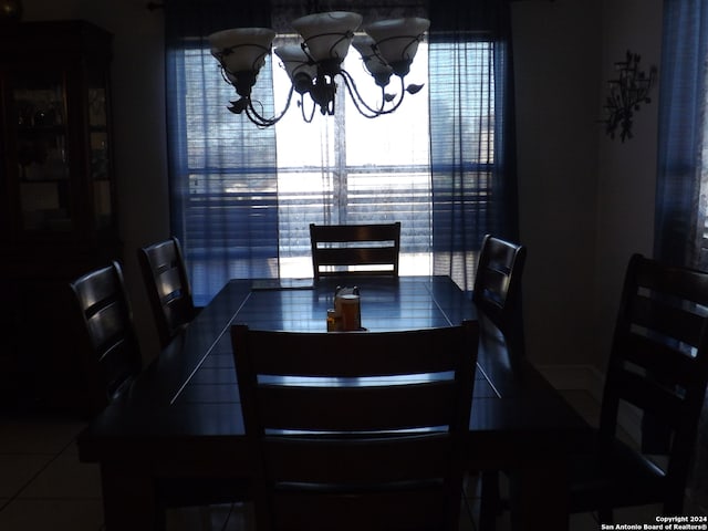 tiled dining area with a notable chandelier and a wealth of natural light