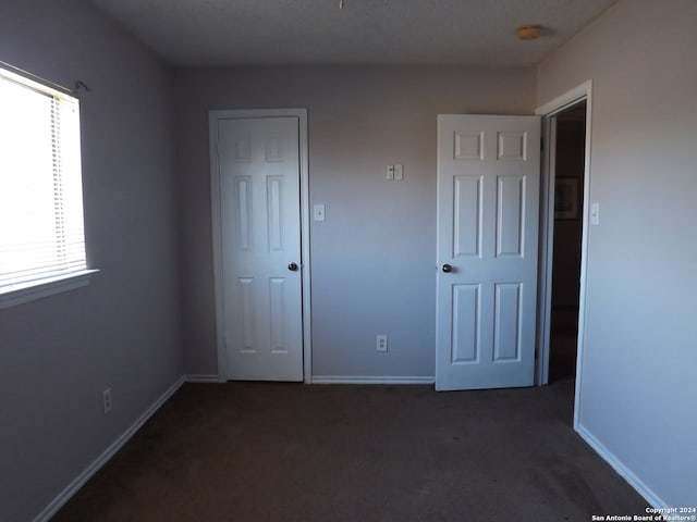 unfurnished bedroom featuring dark colored carpet