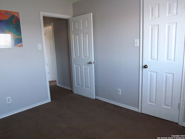 unfurnished bedroom featuring dark carpet