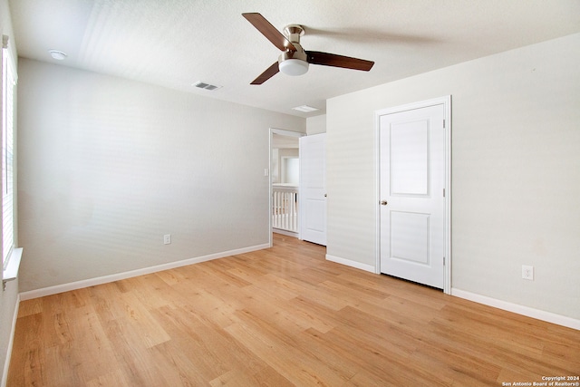 unfurnished bedroom with ceiling fan and light wood-type flooring