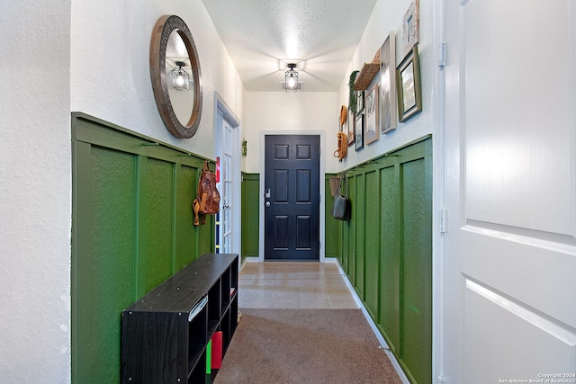 doorway featuring a textured ceiling and tile patterned floors