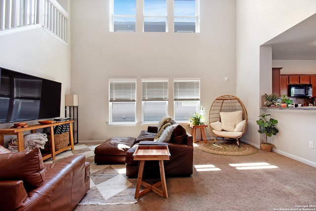 living room with light carpet and a towering ceiling