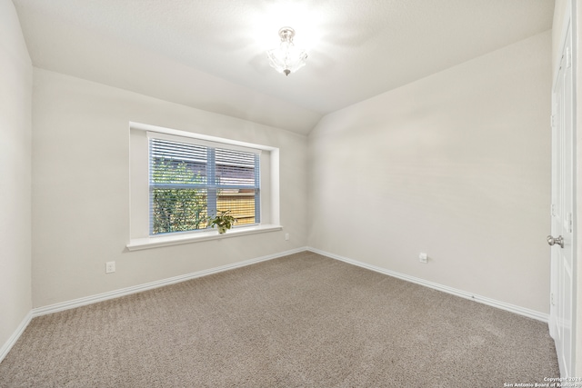 unfurnished room with vaulted ceiling and carpet