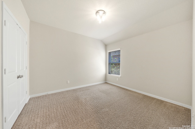 unfurnished bedroom featuring carpet floors and vaulted ceiling